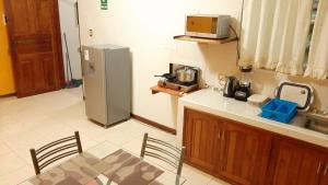 a kitchen with a table and a refrigerator at 102 RV APARTMENTS IQUITOS-APARTAMENTO FAMILIAR CON PISCINA in Iquitos