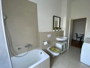 ein Badezimmer mit einer Badewanne, einem WC und einem Waschbecken in der Unterkunft Ruhrpott Apartment Zentral in Herne
