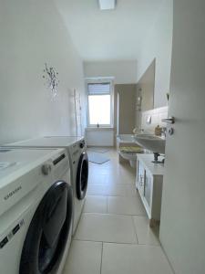 a white bathroom with a washing machine in it at Ruhrpott Apartment Zentral in Herne