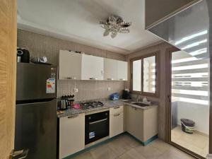 eine Küche mit einem Kühlschrank und einem Herd Top-Backofen in der Unterkunft Appartement Haute Standing Marrakech in Marrakesch