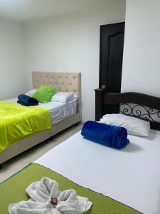2 camas con toallas en una habitación en Mi Balconcito, en Salento