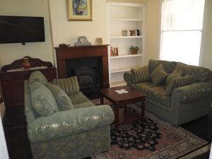 a living room with two couches and a fireplace at Cobblers Cottage B&B in Willunga