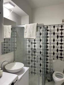 La salle de bains blanche est pourvue de toilettes et d'un lavabo. dans l'établissement Kamche apartment, à Skopje