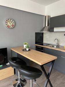 une cuisine avec une table en bois et deux tabourets noirs dans l'établissement Kamche apartment, à Skopje