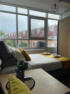 Cette chambre comprend deux lits, un canapé et des fenêtres. dans l'établissement Kamche apartment, à Skopje