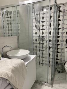 La salle de bains blanche est pourvue d'une douche et d'un lavabo. dans l'établissement Kamche apartment, à Skopje