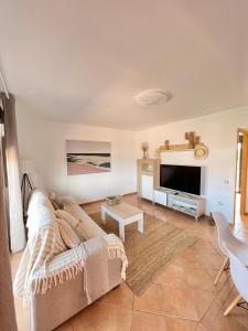 Villa Do Juano في لاجاريس: غرفة معيشة مع أريكة وتلفزيون