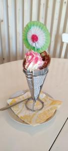 una cesta de helado con una sombrilla en una mesa en Sunnemoslantliv B&B, en Sunnemo