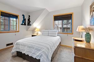 a bedroom with a bed and two windows at 18 Deer Lane in Sunriver