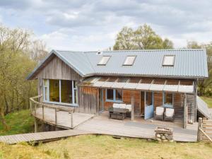 a home with a metal roof and a deck at Sithean in Taynuilt