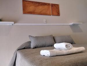 a bed with a white towel on top of it at Home S in Olavarría