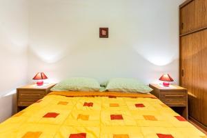a bedroom with a yellow bed with two night stands at Kovacine apartment in Cres
