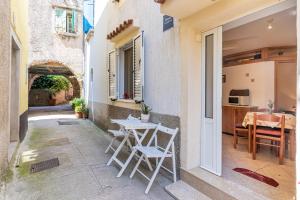 a patio with a table and chairs in a building at Kovacine apartment in Cres