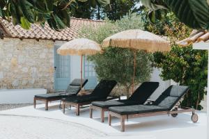 a group of chairs and umbrellas on a patio at Senhora do Cabo Meco Homy Holidays in Sesimbra