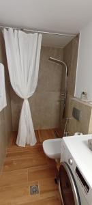 a bathroom with a toilet and a shower curtain at NOCE Luxury Villas Resort in Vourvourou