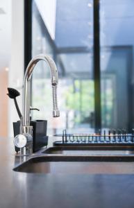 a kitchen sink with a faucet and a counter top at KYMA - Luxurious & Peacefull Apartment in Brussels