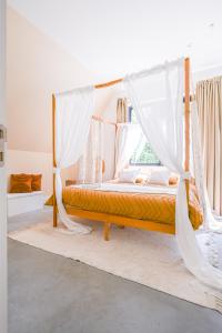 - une chambre avec un lit à baldaquin et des rideaux blancs dans l'établissement KYMA - Luxurious & Peacefull Apartment, à Bruxelles