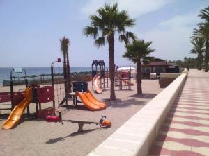 um parque infantil numa praia com palmeiras em Roquetas de mar em Roquetas de Mar