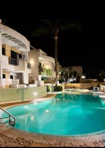 a swimming pool in front of a house at night at Terrazza Merope in Torre dell'Orso