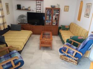 uma sala de estar com dois sofás e uma televisão em Roquetas de mar em Roquetas de Mar