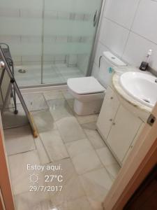 uma casa de banho com um chuveiro, um WC e um lavatório. em Roquetas de mar em Roquetas de Mar