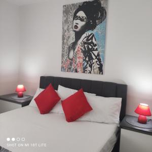 een slaapkamer met een bed met rode kussens en een schilderij bij Apartment T&T Žaborić in Zaboric