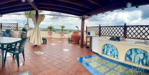 a patio with a kitchen and a table and chairs at Terrazza Merope in Torre dell'Orso