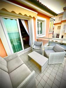 eine Terrasse mit Sofas und Stühlen auf dem Balkon in der Unterkunft Conero Casa - Marcelli di Numana in Via Litoranea 101 in Marcelli
