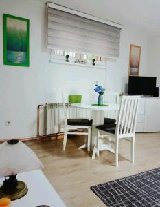 Enaa في سراييفو: غرفة معيشة مع طاولة وكراسي بيضاء
