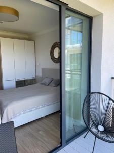 a bedroom with a bed and a sliding glass door at Apartament PLAŻOWY 214 - Rezydencja Niechorze in Niechorze