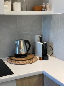 a kitchen counter with a tea kettle and a toaster at Apartament PLAŻOWY 214 - Rezydencja Niechorze in Niechorze