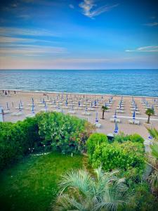einen Strand mit Liegestühlen und Sonnenschirmen und dem Meer in der Unterkunft Conero Casa - Marcelli di Numana in Via Litoranea 101 in Marcelli