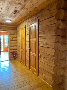 a log cabin hallway with wooden walls and doors at Atpūtas komplekss Dridži in Krāslava