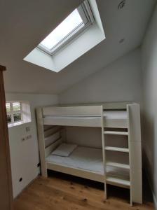 a bedroom with a loft bed with a skylight at Bauhinia Txikia in Guéthary