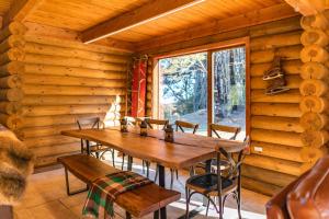 comedor con mesa y sillas en una cabaña de madera en Lyford's Boutique Retreat - Relax & Enjoy, en Mt Lyford