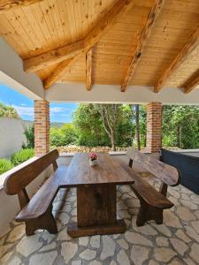 a wooden table and two benches on a patio at Holiday homes Sintija in Rab