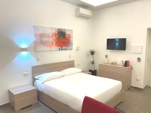 ein Schlafzimmer mit einem Bett und einem TV an der Wand in der Unterkunft Manfredi House San Pietro in Rom