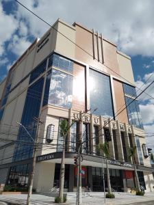 a building with a lot of windows on a street at Apartamento Completo A25 Flat Centro in Mogi das Cruzes