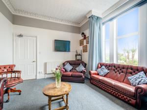 a living room with two leather couches and a table at Braefield in Portpatrick