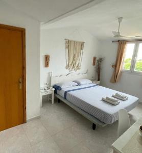 1 dormitorio con cama, mesa y ventana en Atico excelente en Menorca Ciutadella Calan Blanes, en Cala en Forcat