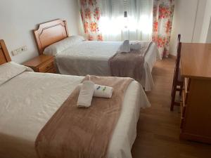 a hotel room with two beds with towels on them at Camiño Portugues in Padrón
