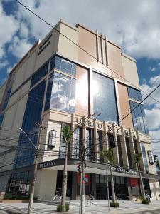 a building with a lot of windows on a street at Apartamento A 43 Flat Centro in Mogi das Cruzes