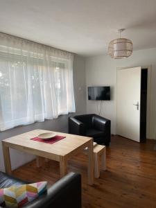 uma sala de estar com uma mesa e uma sala de estar com um sofá em Seeblick Bungalow em Arendsee