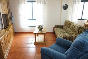 uma sala de estar com um sofá e uma mesa em Hermanas Iglesias em O Vicedo