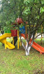 un groupe de toboggans dans un parc avec un arbre dans l'établissement Beyaz Köşk Geyve, à Geyve