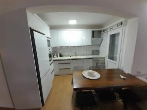 eine Küche mit einem Holztisch und einem weißen Kühlschrank in der Unterkunft Villa suzi in Kusadası
