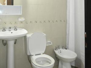 Baño blanco con aseo y lavamanos en Alojamiento Las Camelias en Concordia