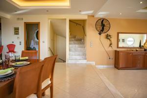 une salle à manger avec une table et une horloge au mur dans l'établissement Mary's Luxury Residence, à Koskinou