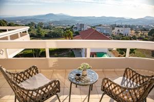 un balcon avec une table et des chaises et une vue dans l'établissement Mary's Luxury Residence, à Koskinou