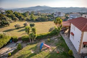 une vue aérienne d'une maison avec une cour et une aire de jeux dans l'établissement Mary's Luxury Residence, à Koskinou